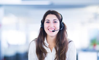 A headshot of a smiling business woman wearing a headset.